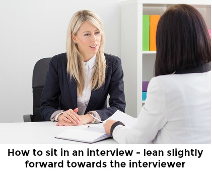 Mujer inclinándose ligeramente hacia el entrevistador con palabras 